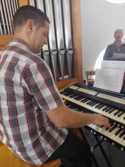Markus Asböck an der elektischen Orgel bei der Begleitung des Kirchenchores. 
